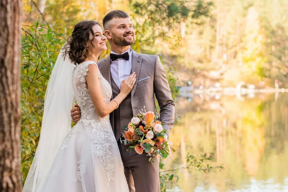 Bride and groom wearing wedding attire outdoors